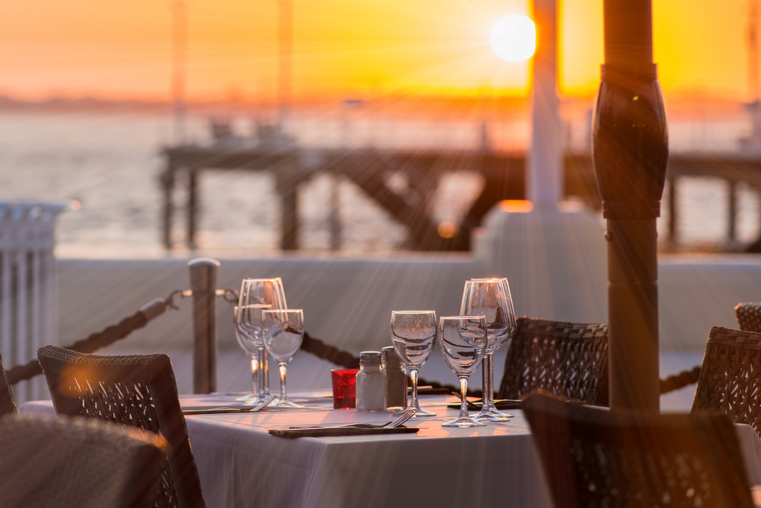 beautiful dining set up in front of a waterfront sunset setting